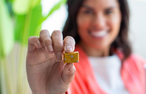 A woman holding up a Energy+ Wellness Chew.